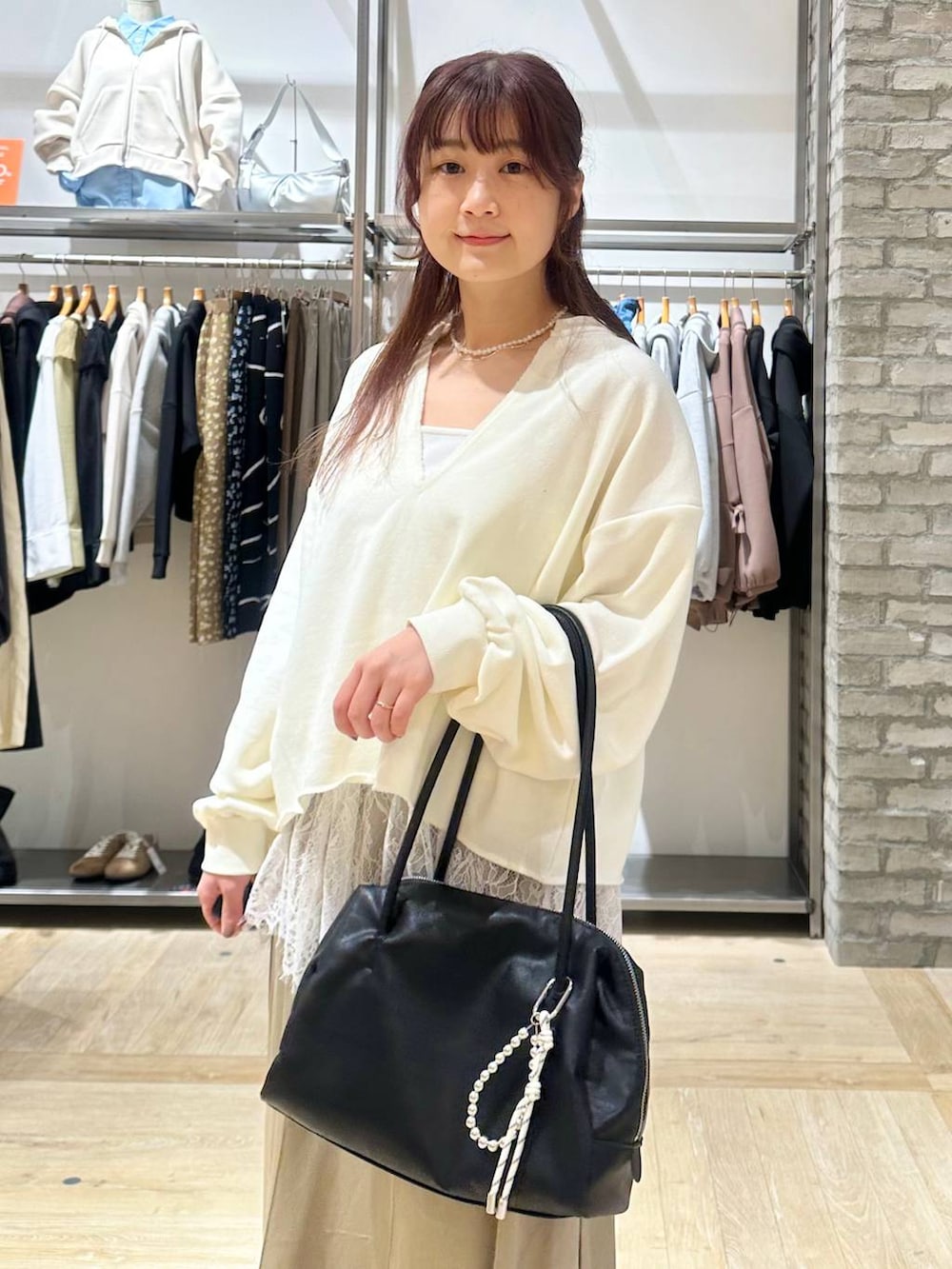 ブラック系のボストンバッグ、ホワイト系のキャミソール、ホワイト系のTシャツ/カットソーを着用したレディースの春コーディネートの4枚目の写真