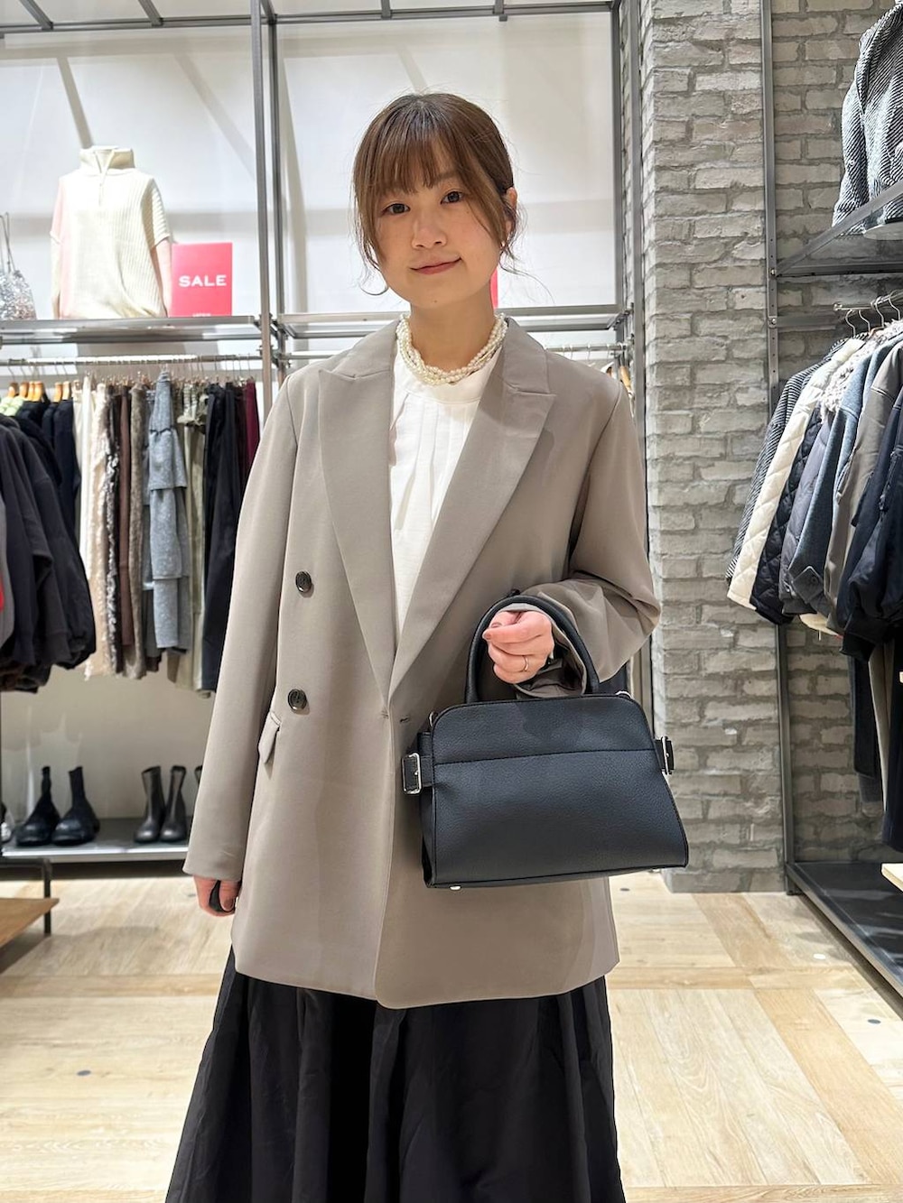 ブラウン系のテーラードジャケット、ブラック系のスカート、ホワイト系のシャツ/ブラウスを着用したレディースの冬コーディネートの4枚目の写真