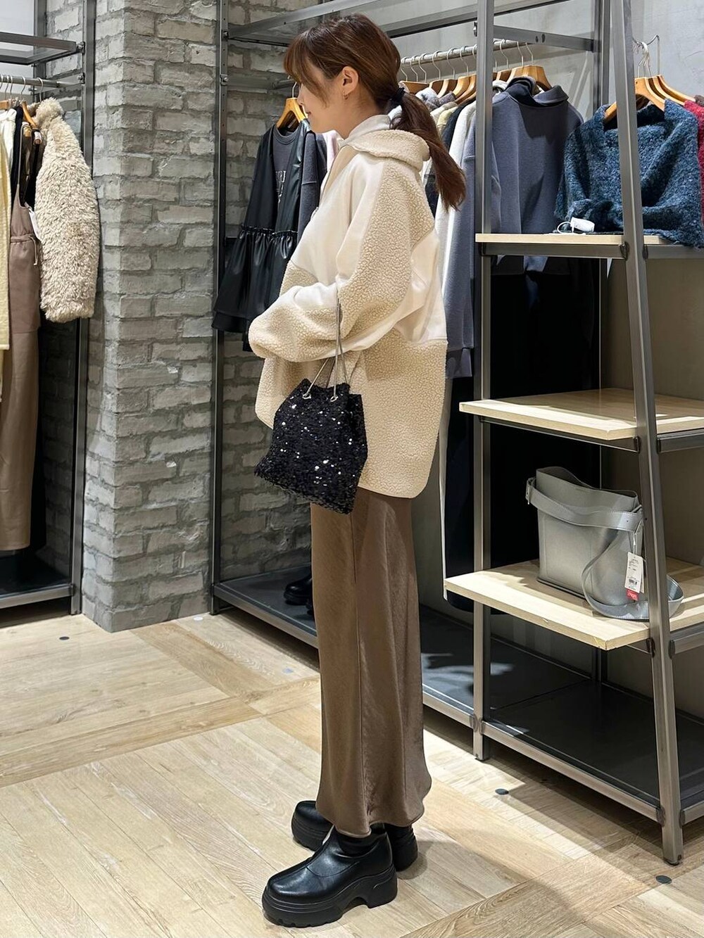 ホワイト系のTシャツ/カットソー、ブラウン系のスカート、ブラック系のブーツを着用したレディースの冬コーディネートの2枚目の写真