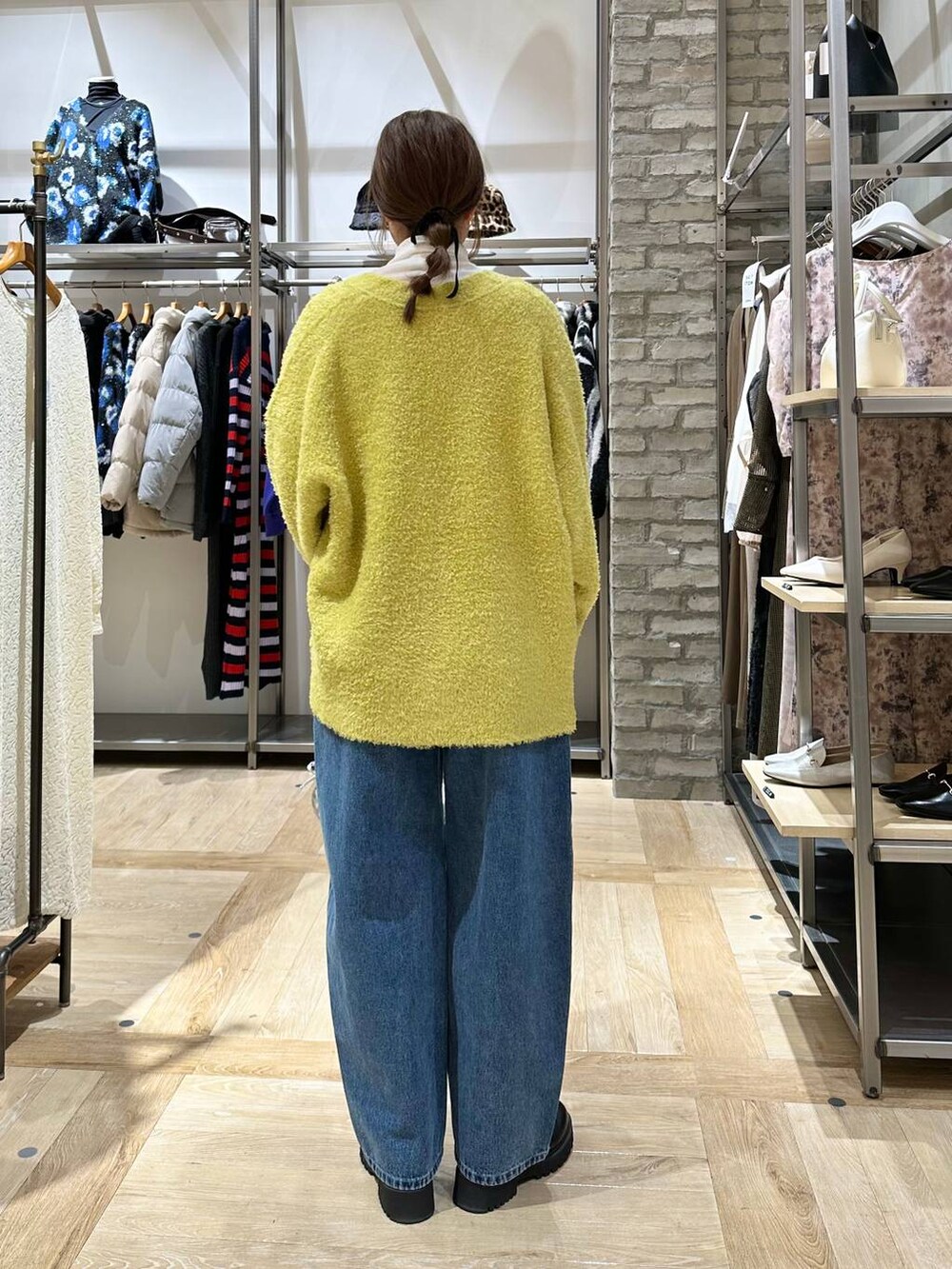 ホワイト系のTシャツ/カットソー、ブラック系のブーツ、ブルー系のデニムパンツを着用したレディースの冬コーディネートの3枚目の写真