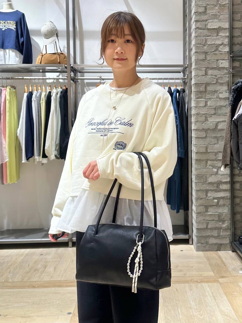 ブラック系のサンダル、ホワイト系のTシャツ/カットソー、ブラック系のボストンバッグを着用したレディースの冬コーディネートの4枚目の写真