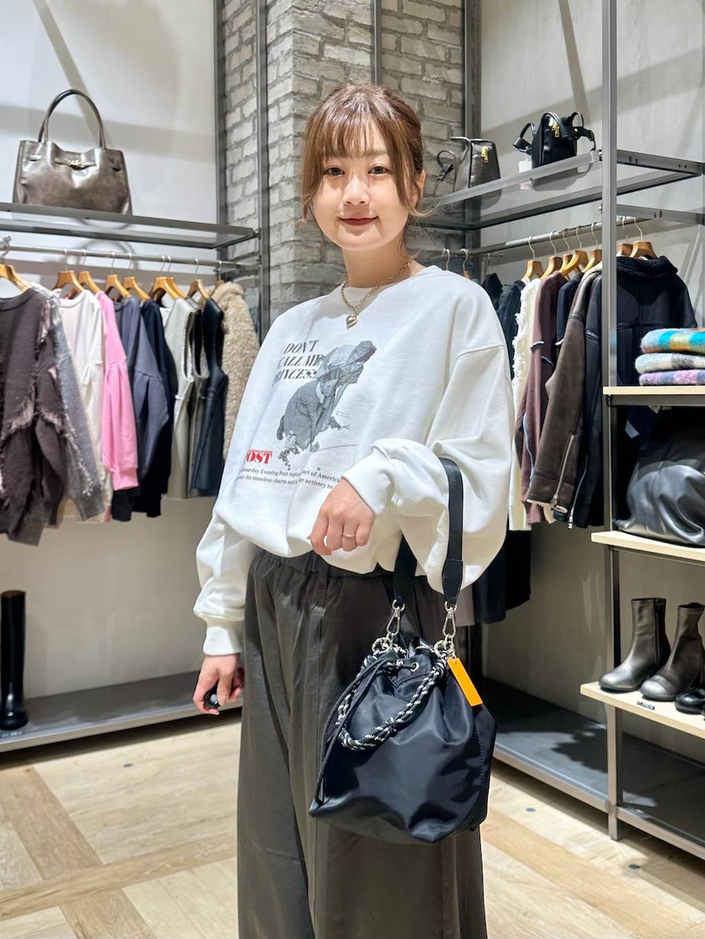 ブラック系のショルダーバッグ、ホワイト系のブルゾン、グレー系のその他パンツを着用したレディースの冬コーディネートの4枚目の写真