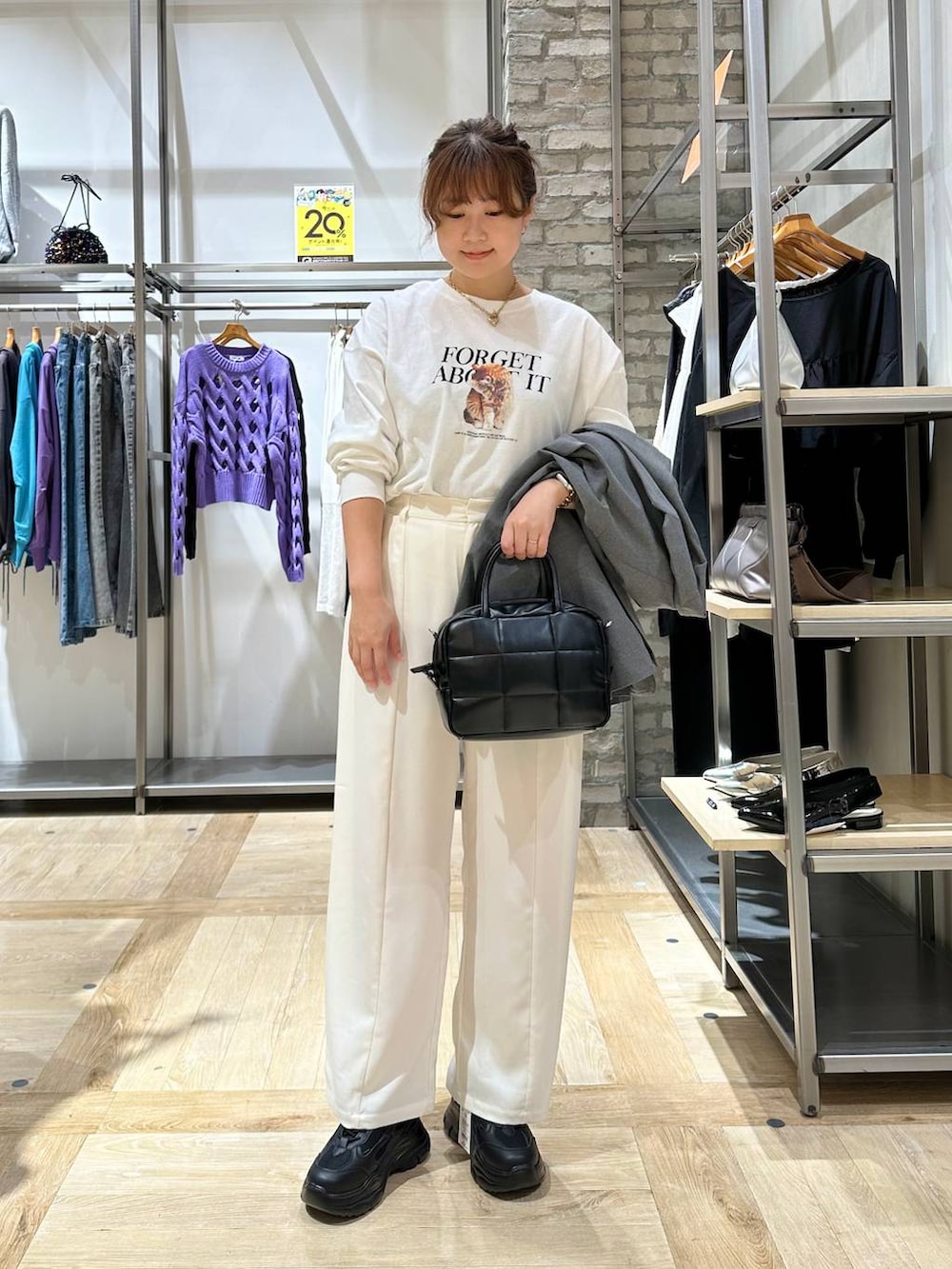 グレー系のテーラードジャケット、ブラック系のスニーカー、ブラック系のボストンバッグを着用したレディースの秋コーディネートの4枚目の写真