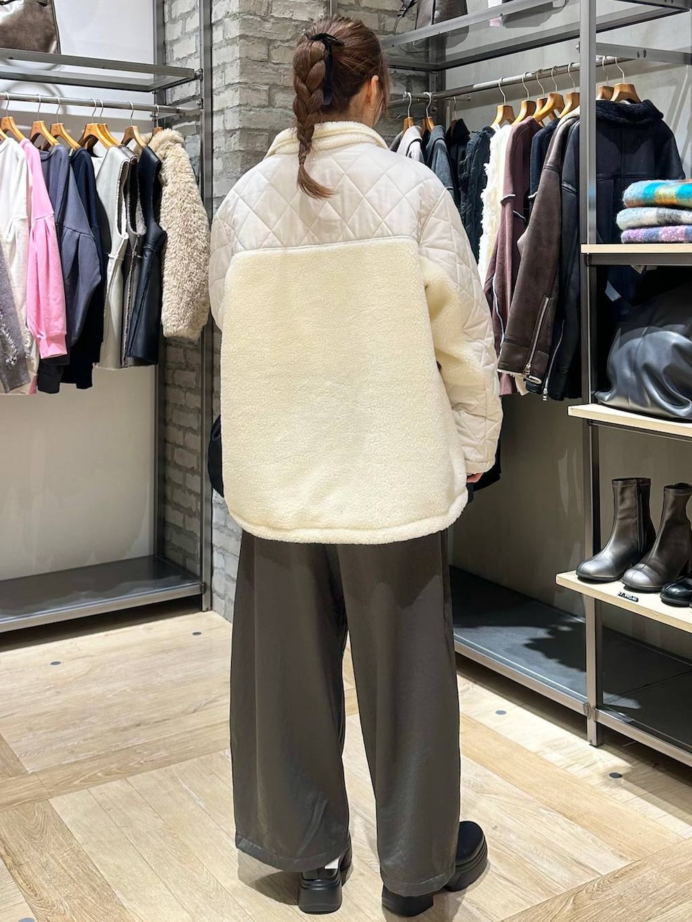 ブラック系のショルダーバッグ、ホワイト系のブルゾン、グレー系のその他パンツを着用したレディースの冬コーディネートの7枚目の写真