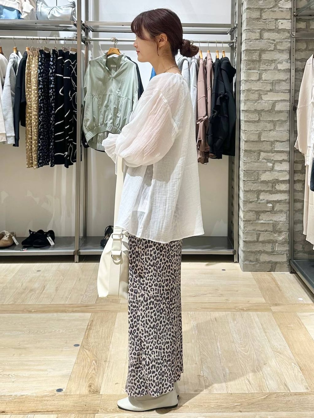 ホワイト系のショルダーバッグ、ホワイト系のパンプス、ホワイト系のシャツ/ブラウスを着用したレディースの春コーディネートの2枚目の写真