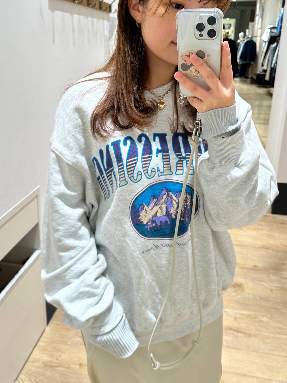 グレー系のTシャツ/カットソー、ホワイト系のスカート、グレー系のスウェットを着用したレディースの冬コーディネートの4枚目の写真