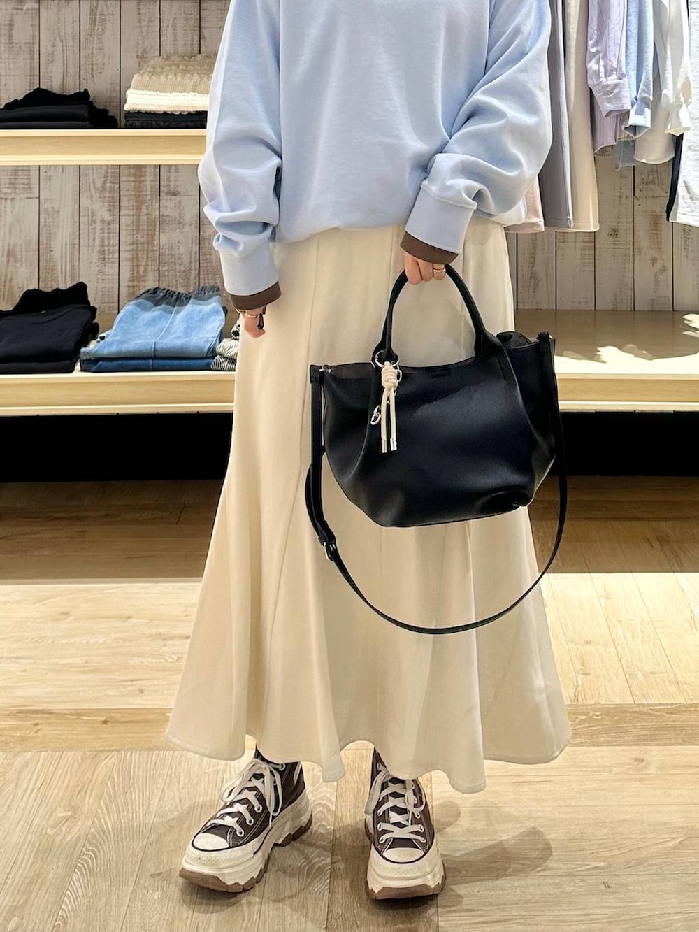 ホワイト系のスカート、ブラック系のトートバッグ、ブルー系のTシャツ/カットソーを着用したレディースの冬コーディネートの5枚目の写真