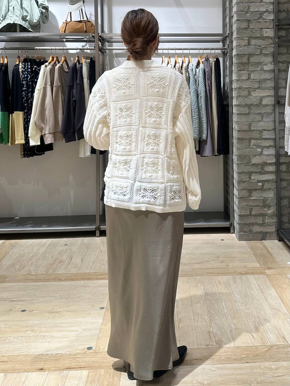 グリーン系のスカート、ホワイト系のTシャツ/カットソー、ブラック系のボストンバッグを着用したレディースの春コーディネートの3枚目の写真