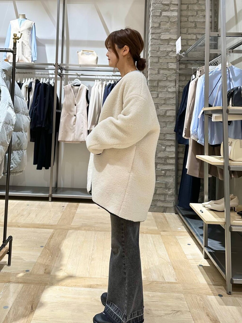 ホワイト系のその他アウター、ブラック系のデニムパンツ、ブラック系のスニーカーを着用したレディースの冬コーディネートの2枚目の写真