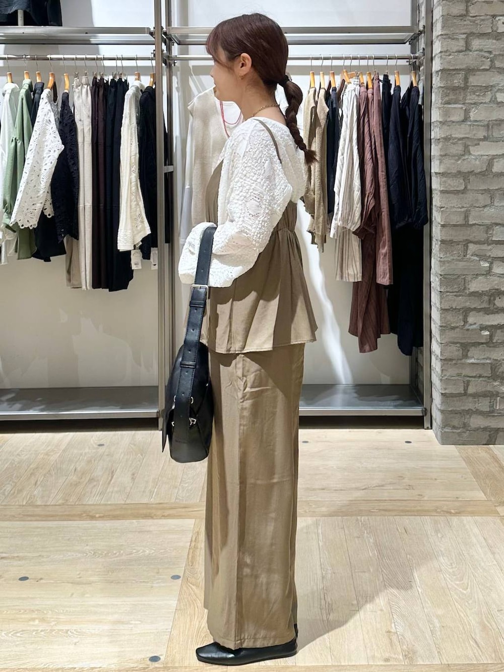 ブラック系のショルダーバッグ、ホワイト系のTシャツ/カットソー、ブラック系のパンプスを着用したレディースの春コーディネートの2枚目の写真