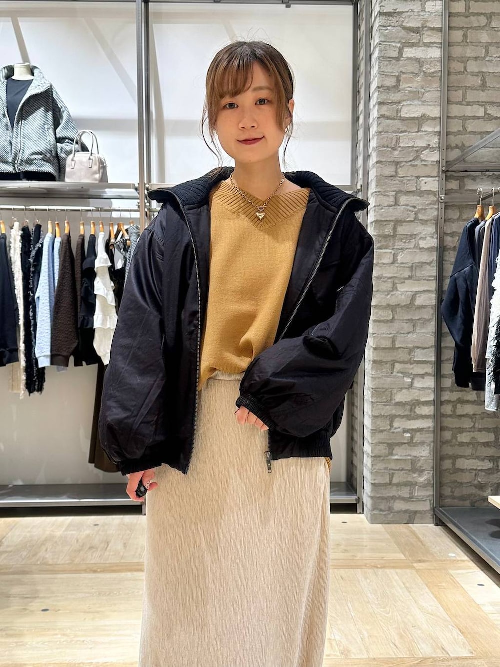 イエロー系のニット/セーター、ブラック系のボストンバッグ、ブラック系のブーツを着用したレディースの秋コーディネートの4枚目の写真