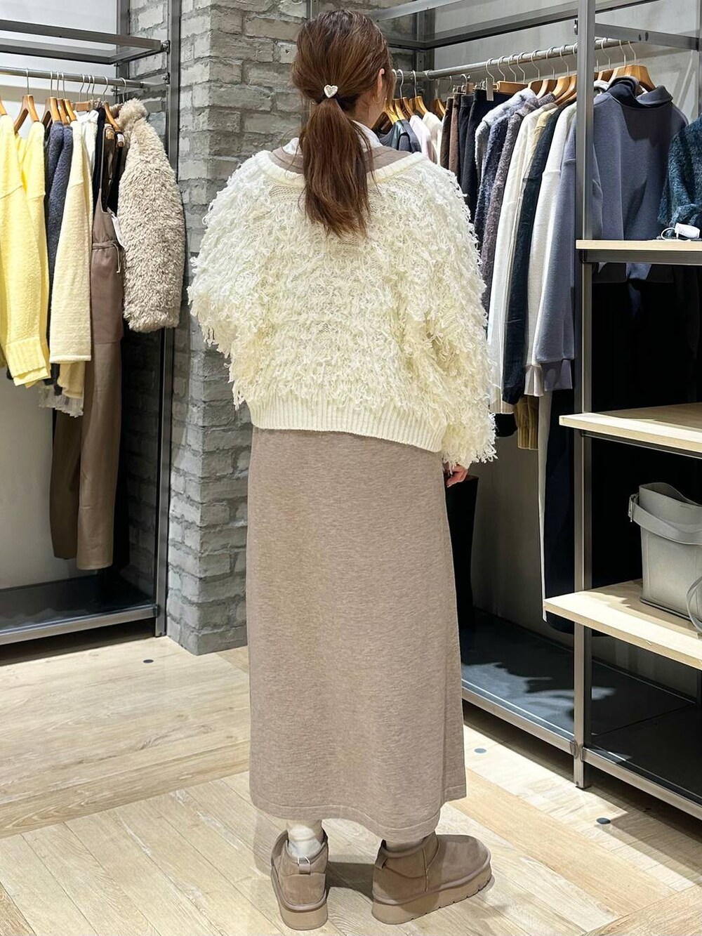 ホワイト系のTシャツ/カットソー、ブラック系のショルダーバッグ、ホワイト系のニット/セーターを着用したレディースの冬コーディネートの4枚目の写真