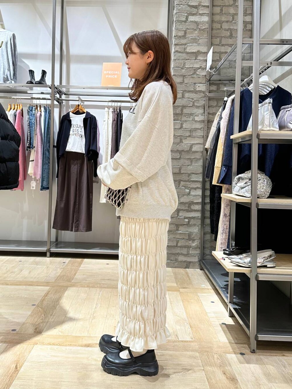 ブラック系のスニーカー、ホワイト系のスカート、ベージュ系のTシャツ/カットソーを着用したレディースの秋コーディネートの3枚目の写真