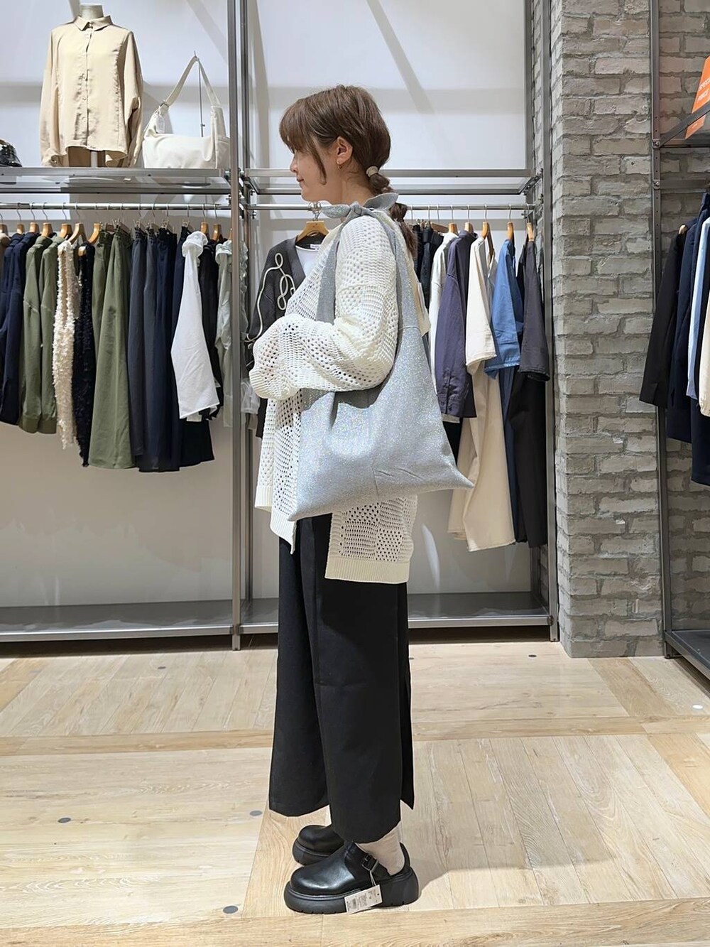ホワイト系のTシャツ/カットソー、ブラック系のサンダル、ブラック系のショルダーバッグを着用したレディースの春コーディネートの2枚目の写真