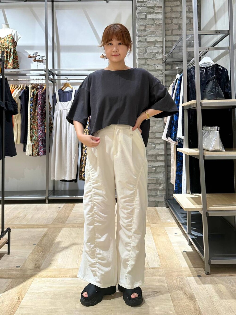 グレー系のTシャツ/カットソー、ブラック系のサンダル、グレー系のショルダーバッグを着用したレディースの夏コーディネートの2枚目の写真