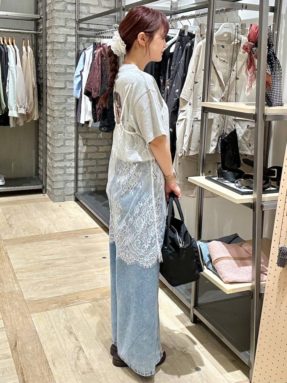 ブルー系のデニムパンツ、ブラック系のトートバッグ、ブラウン系のサンダルを着用したレディースの春コーディネートの2枚目の写真