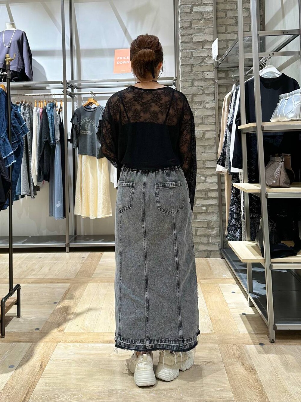 ホワイト系のスニーカー、グレー系のスカート、ブラック系のTシャツ/カットソーを着用したレディースの秋コーディネートの3枚目の写真