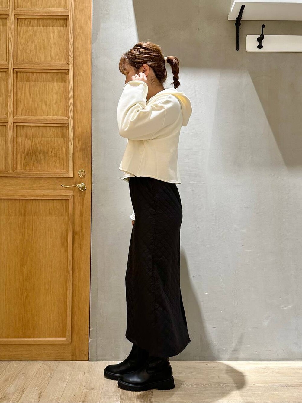 ホワイト系のパーカー、ブラック系のショルダーバッグ、ブラック系のスカートを着用したレディースの秋コーディネートの6枚目の写真