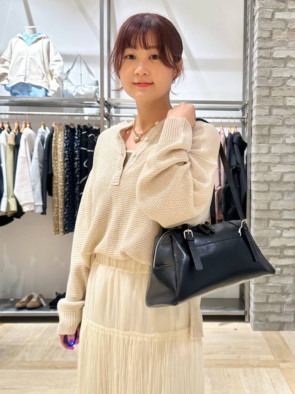 ブラック系のボストンバッグ、ブラック系のその他シューズ、ホワイト系のスカートを着用したレディースの春コーディネートの6枚目の写真