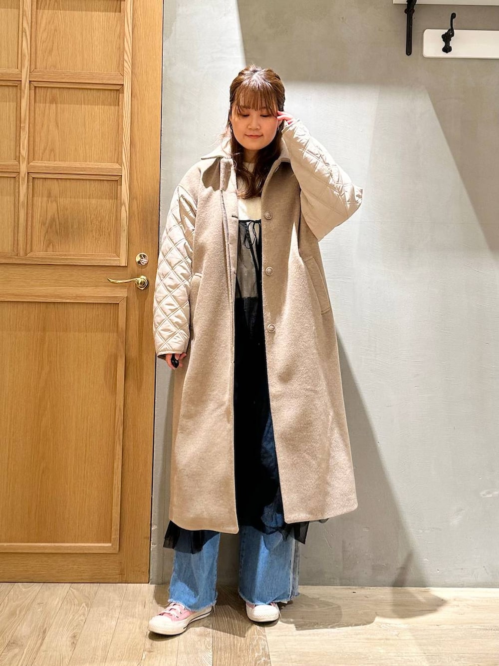 ブラック系のトートバッグ、ブルー系のデニムパンツ、ホワイト系のニット/セーターを着用したレディースの冬コーディネートの2枚目の写真