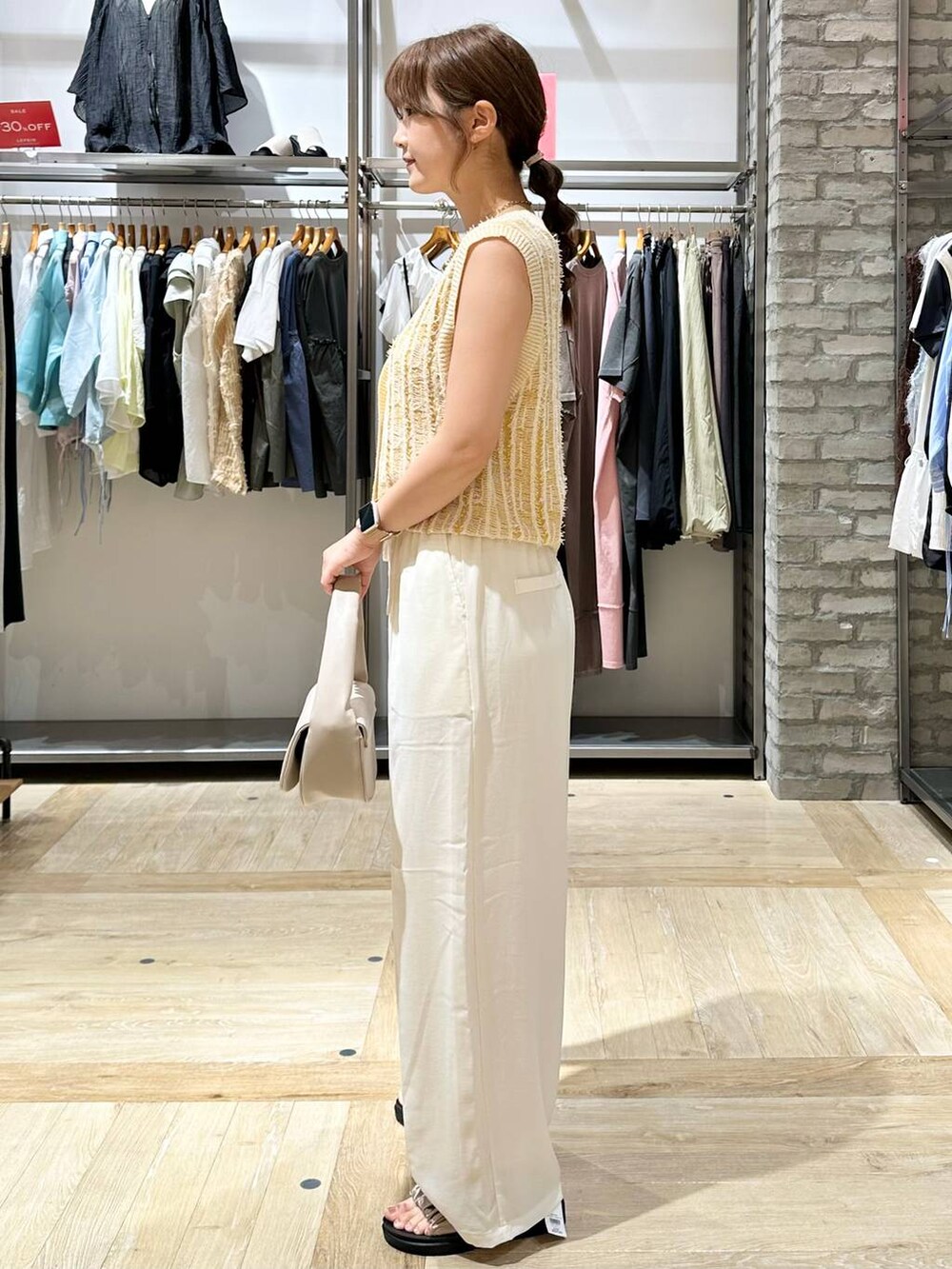 ホワイト系のその他パンツ、ホワイト系のタンクトップ、ベージュ系のサンダルを着用したレディースの夏コーディネートの2枚目の写真