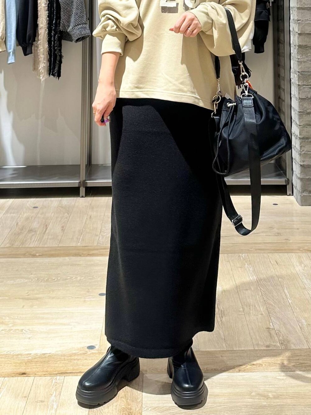 ブラック系のショルダーバッグ、ブラック系のスカート、ホワイト系のその他アウターを着用したレディースの秋コーディネートの6枚目の写真