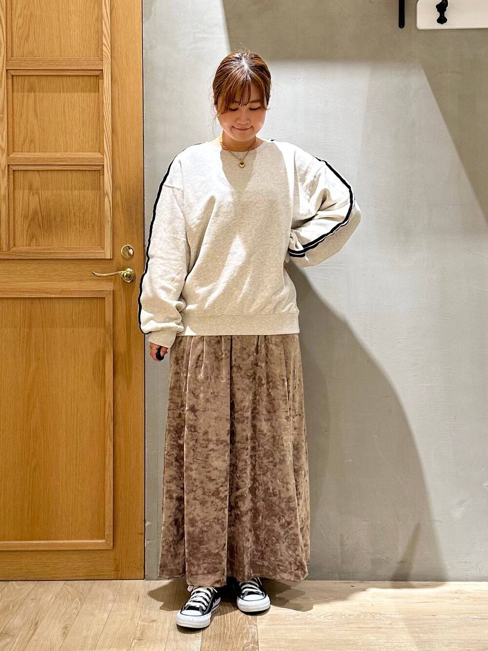 ブラウン系のワンピース、グレー系のTシャツ/カットソー、ゴールド系のピアス（両耳用）を着用したレディースの秋コーディネートの2枚目の写真