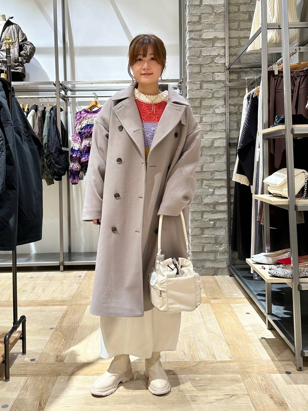 ホワイト系のスカート、ホワイト系のブーツ、ホワイト系のショルダーバッグを着用したレディースの秋コーディネートの5枚目の写真