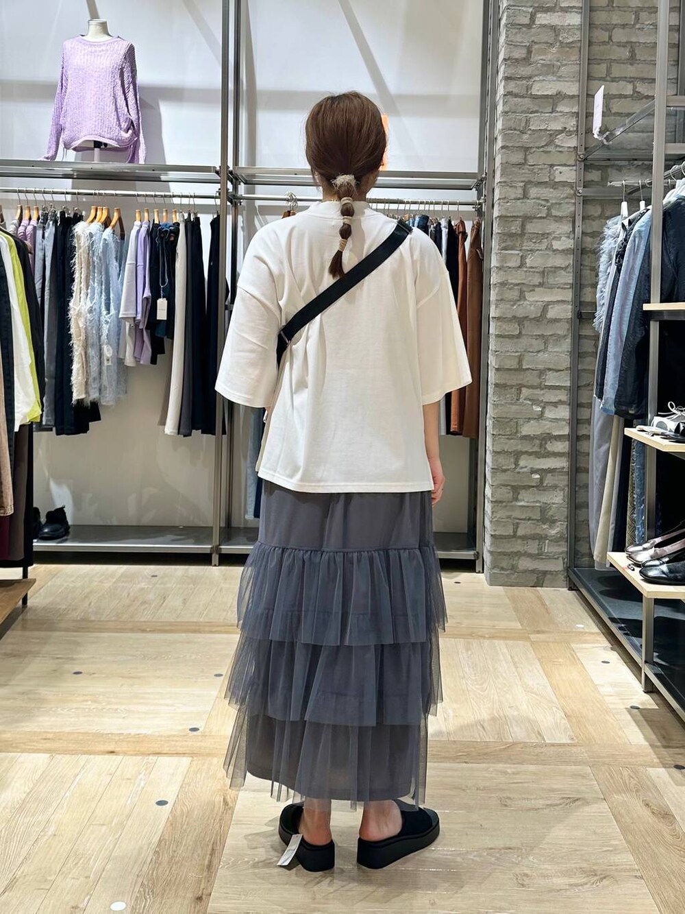 ホワイト系のTシャツ/カットソー、ブラック系のショルダーバッグ、ブラック系のサンダルを着用したレディースの春コーディネートの3枚目の写真