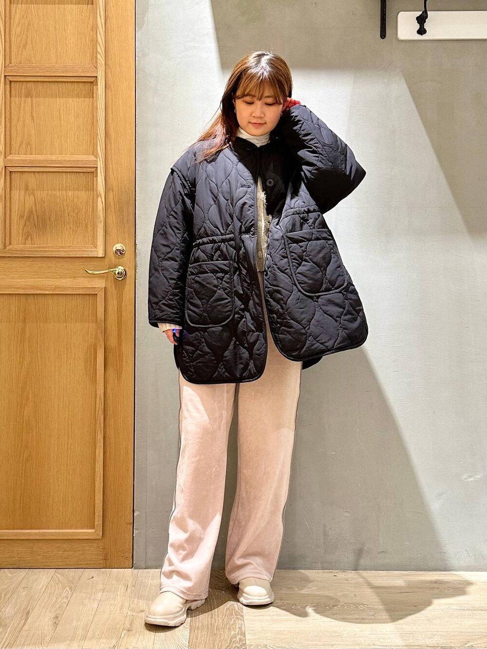 ホワイト系のTシャツ/カットソー、ブラック系のその他アウター、ホワイト系のブーツを着用したレディースの冬コーディネートの2枚目の写真