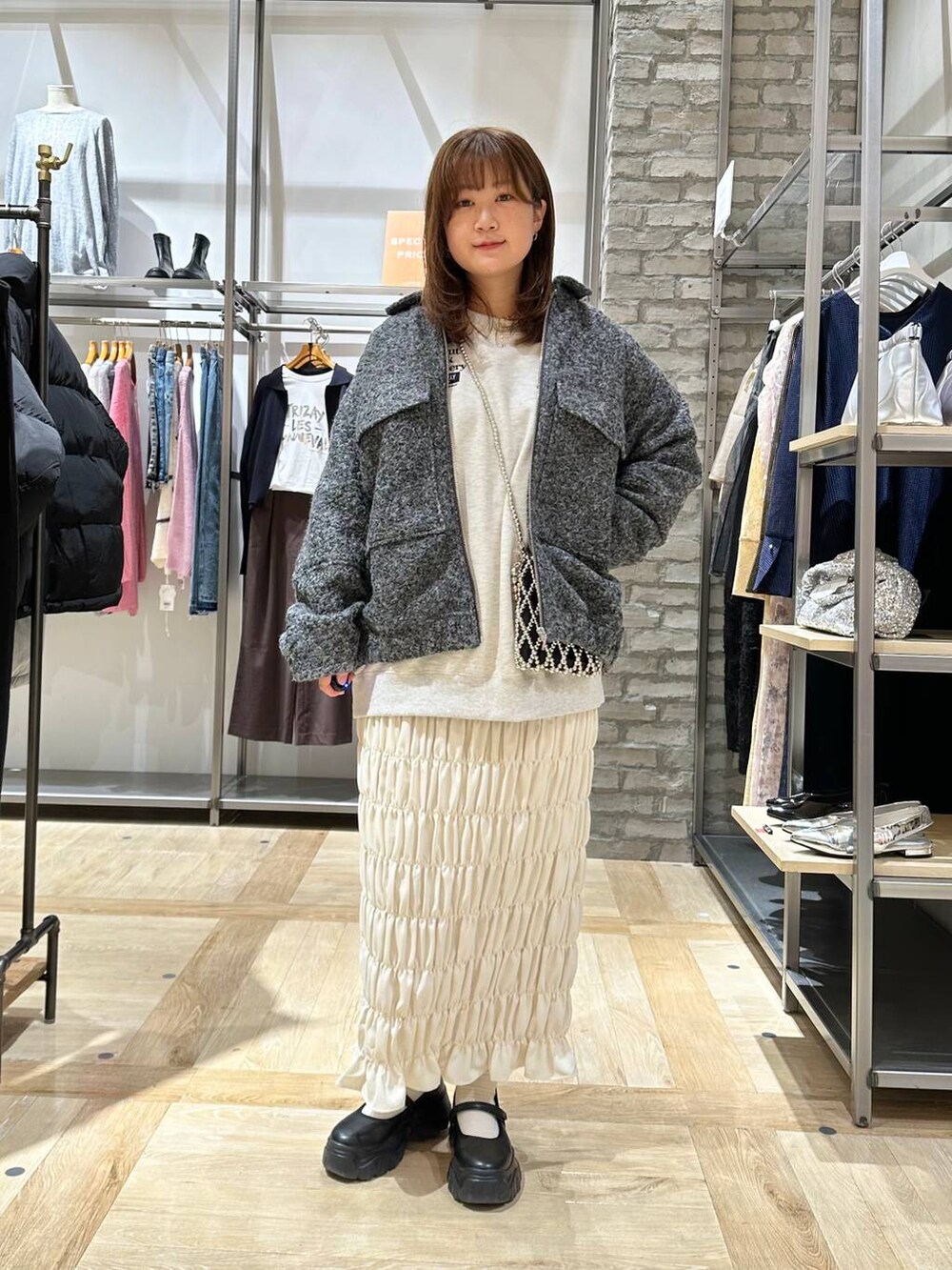 ブラック系のスニーカー、ホワイト系のスカート、ベージュ系のTシャツ/カットソーを着用したレディースの秋コーディネートの5枚目の写真