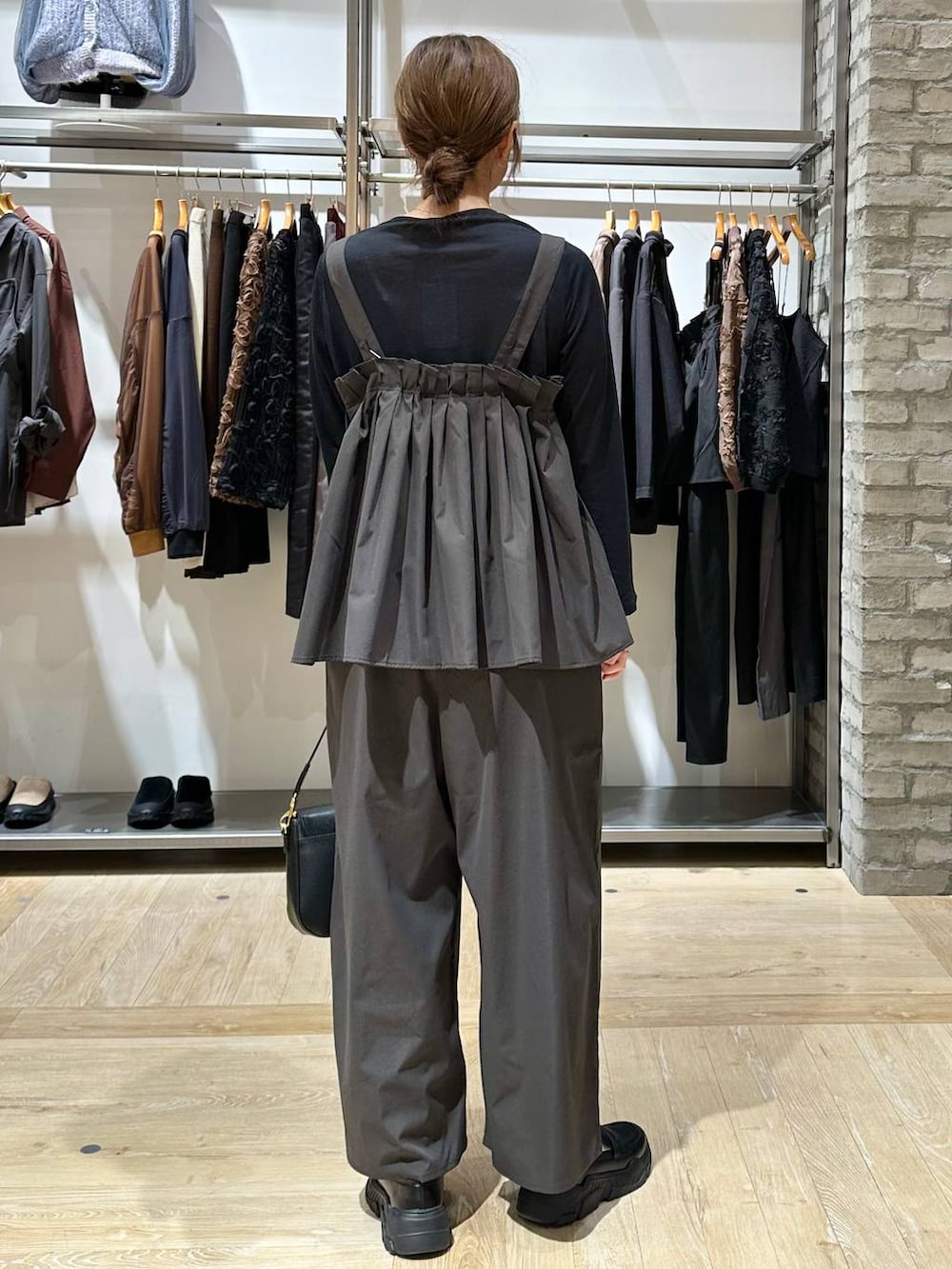 ブラック系のスニーカー、ブラック系のショルダーバッグ、グレー系のサロペット/オーバーオールを着用したレディースの秋コーディネートの4枚目の写真