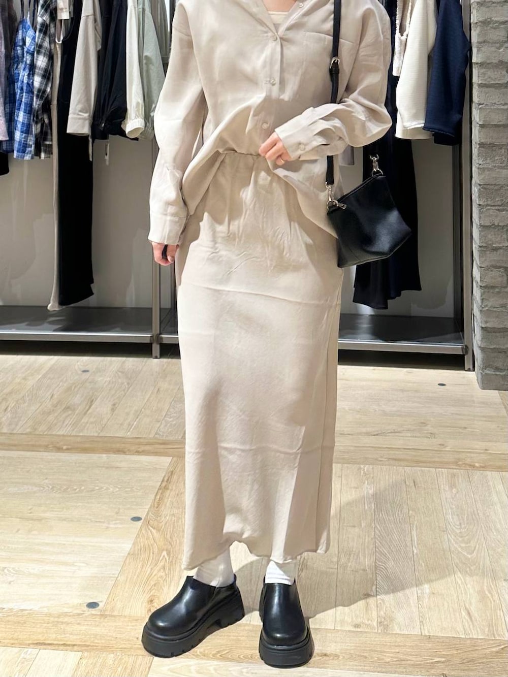 ブラック系のその他シューズ、ブラック系のトートバッグ、ベージュ系のスカートを着用したレディースの春コーディネートの5枚目の写真