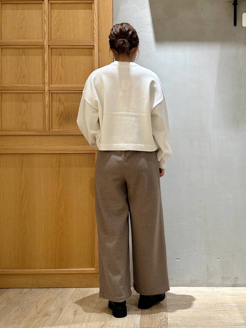 ベージュ系のショルダーバッグ、ブラック系のブーツ、ホワイト系のニット/セーターを着用したレディースの冬コーディネートの4枚目の写真