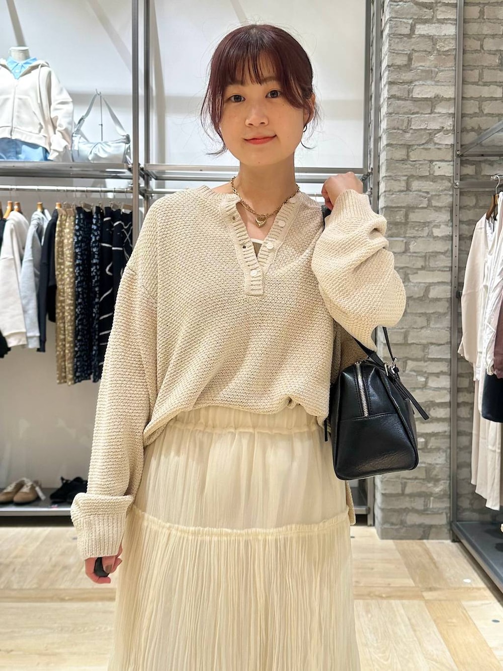 ブラック系のボストンバッグ、ブラック系のその他シューズ、ホワイト系のスカートを着用したレディースの春コーディネートの4枚目の写真