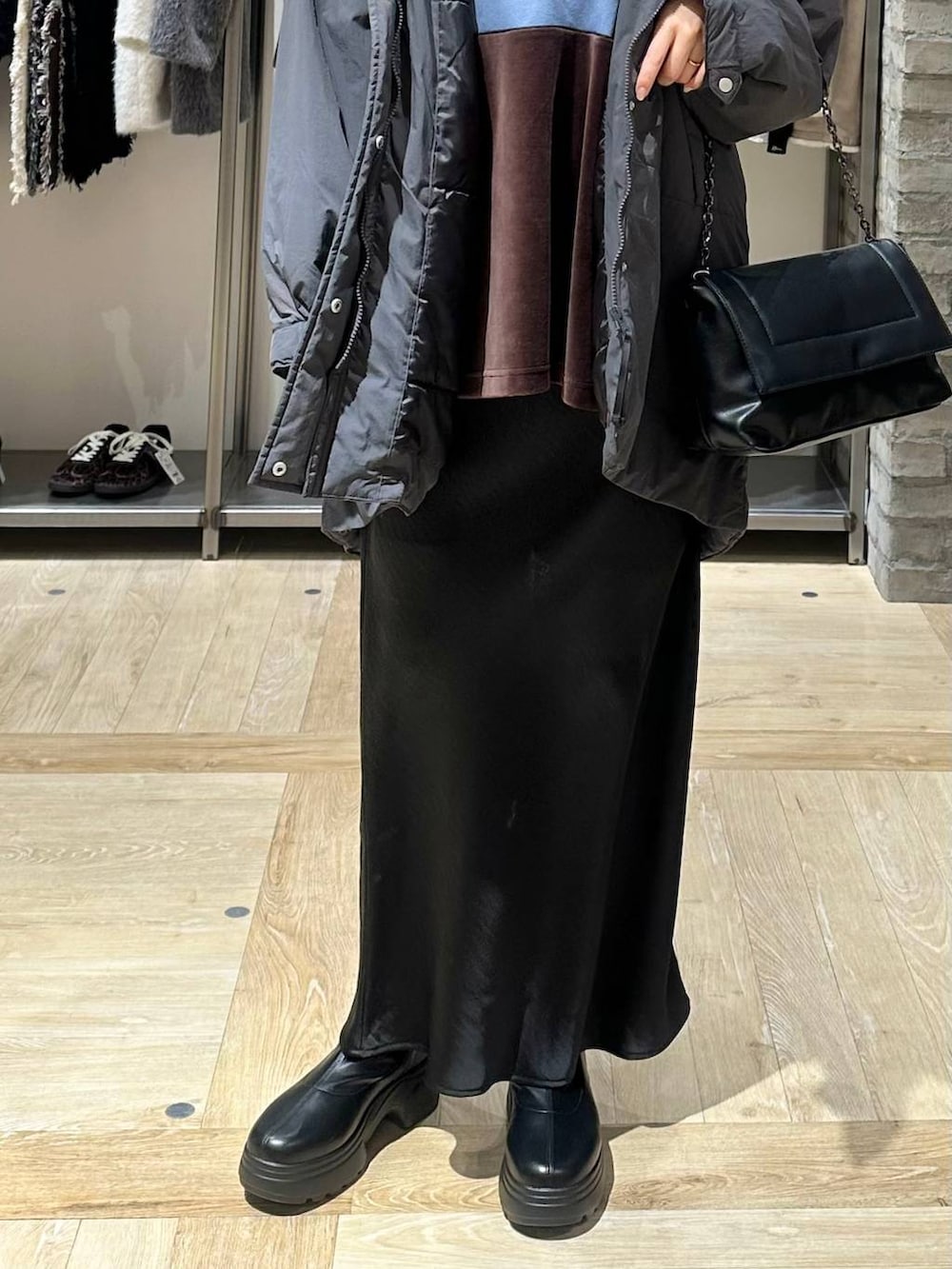 ブラック系のスカート、グレー系のその他アウター、ブラック系のブーツを着用したレディースの冬コーディネートの4枚目の写真