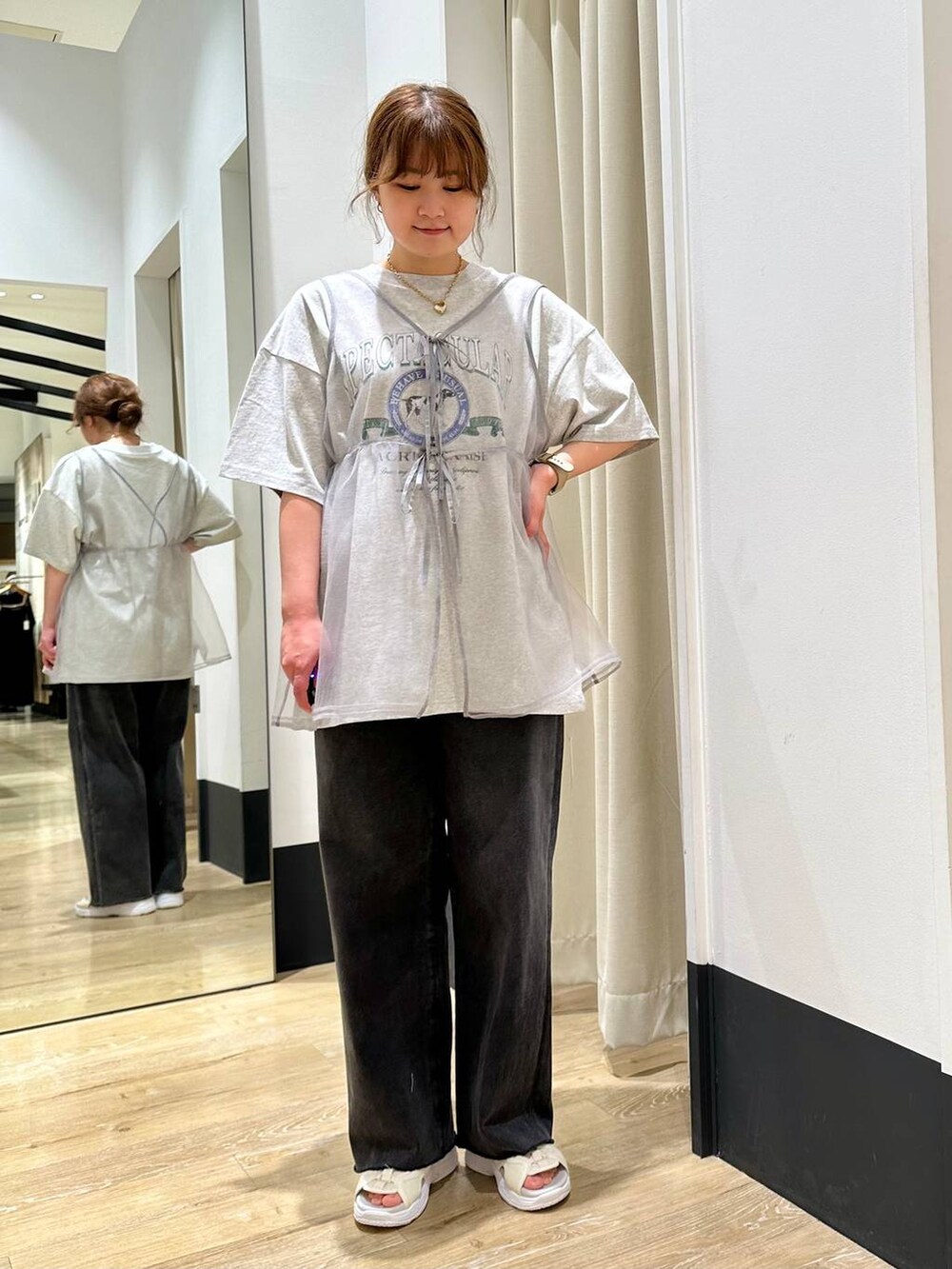 ホワイト系のサンダル、グレー系のベスト、ブラック系のデニムパンツを着用したレディースの春コーディネートの3枚目の写真