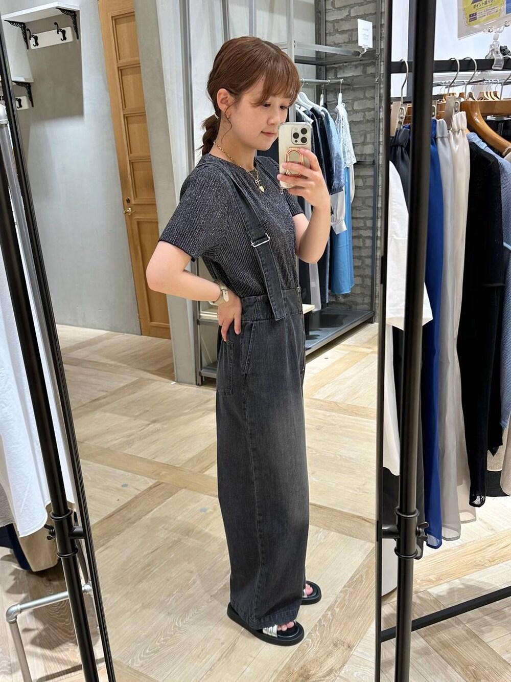 グレー系のデニムパンツ、シルバー系のサンダル、ブラック系のTシャツ/カットソーを着用したレディースの春コーディネートの3枚目の写真