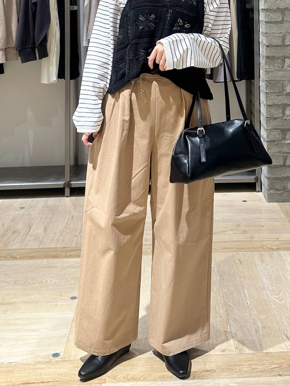 ブラック系のボストンバッグ、ホワイト系のTシャツ/カットソー、ベージュ系のその他パンツを着用したレディースの春コーディネートの5枚目の写真