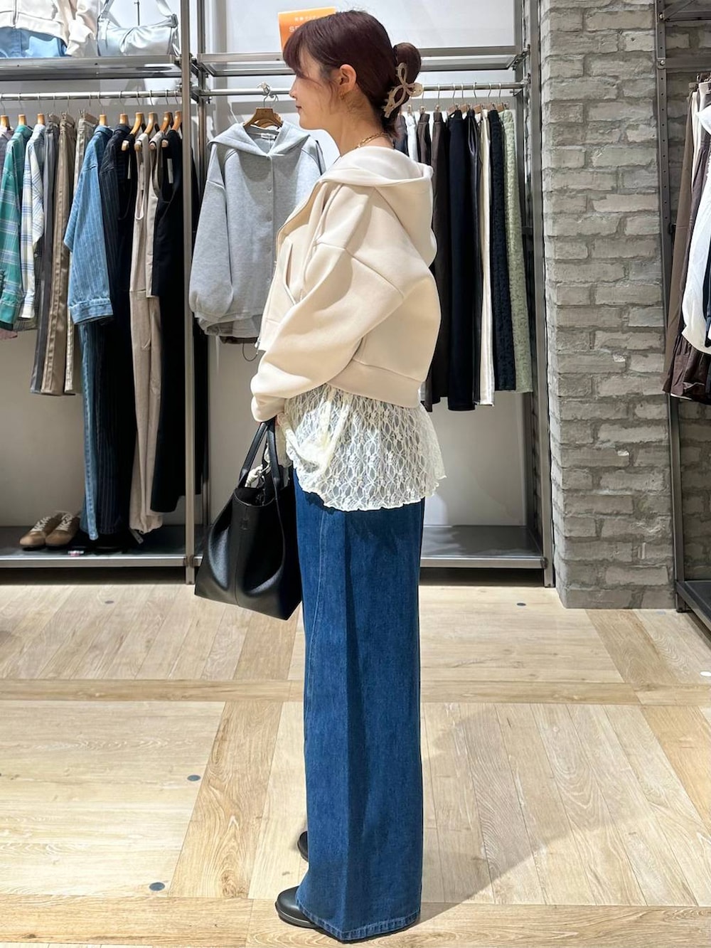 ブラック系のパンプス、ホワイト系のシャツ/ブラウス、ブラック系のトートバッグを着用したレディースの春コーディネートの2枚目の写真