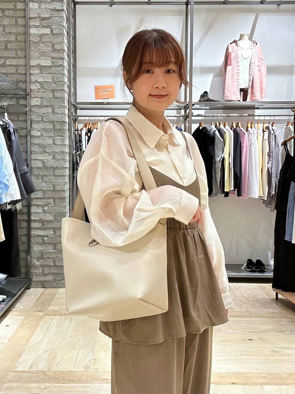 ホワイト系のシャツ/ブラウス、ホワイト系のトートバッグ、ホワイト系のパンプスを着用したレディースの春コーディネートの4枚目の写真