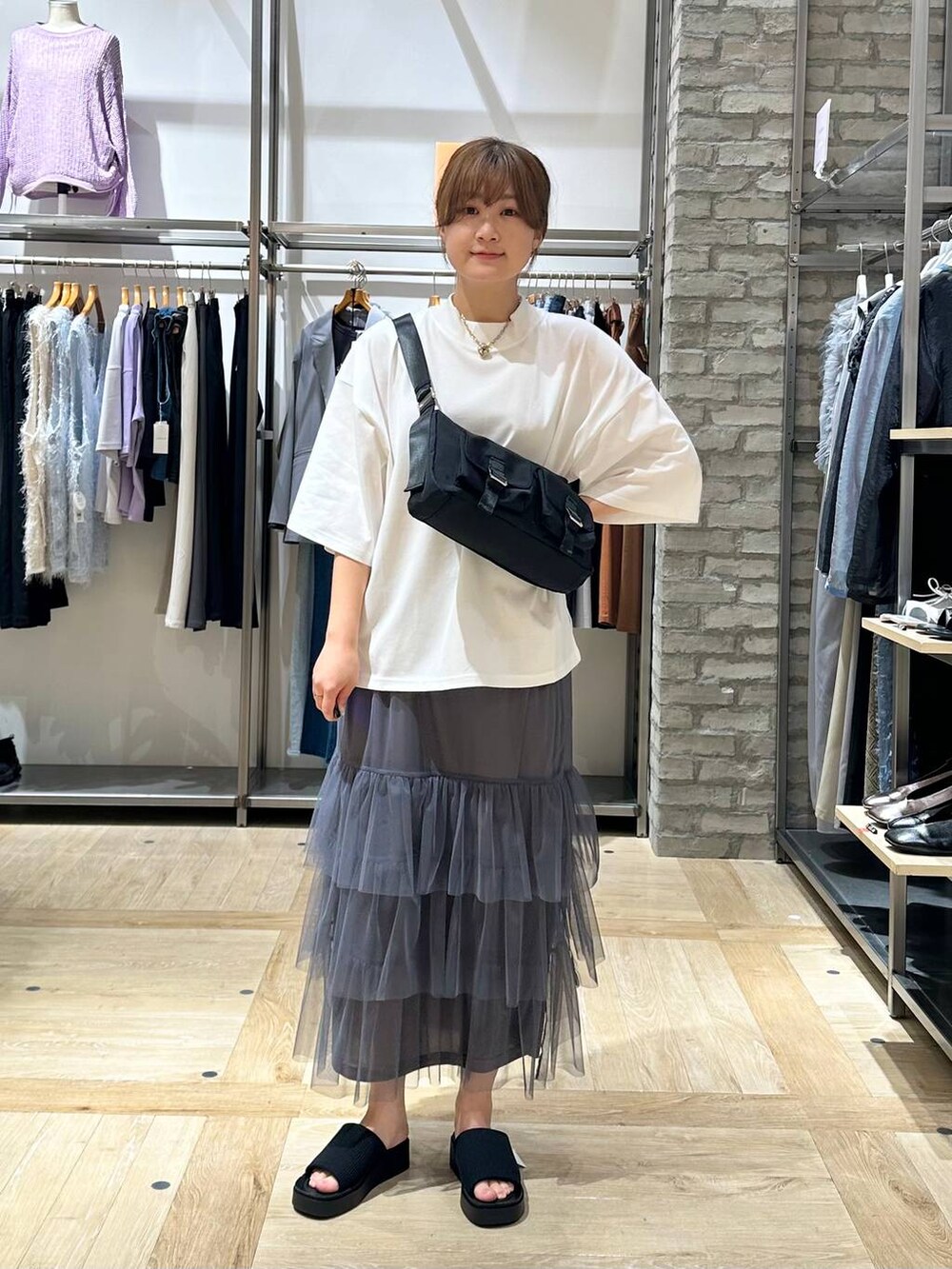 ホワイト系のTシャツ/カットソー、ブラック系のショルダーバッグ、ブラック系のシャツ/ブラウスを着用したレディースの春コーディネートの4枚目の写真