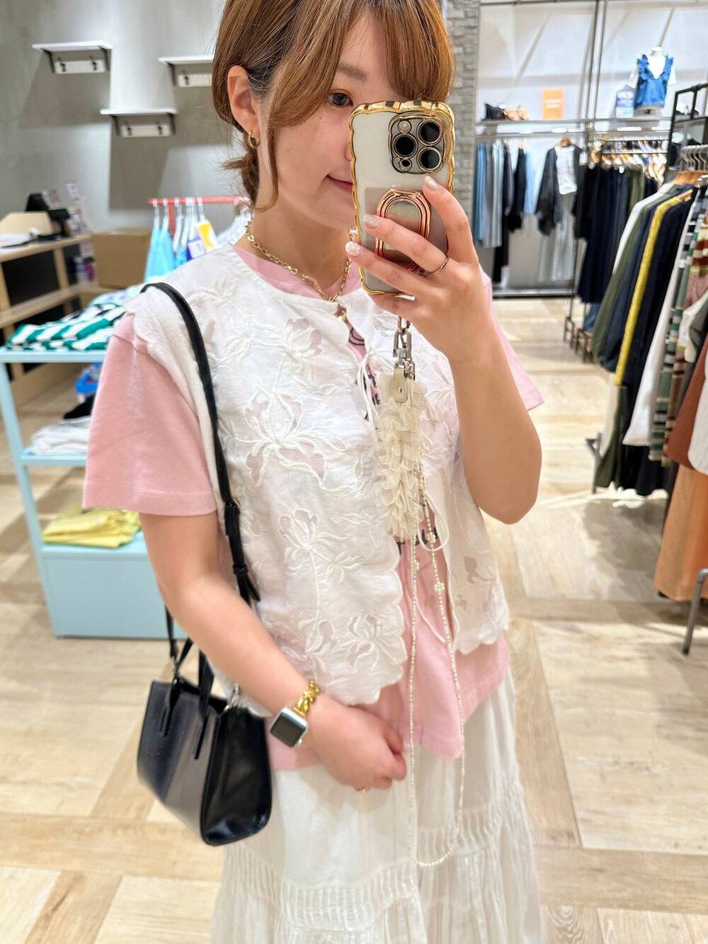 ホワイト系のベスト、ブラック系のショルダーバッグ、ブラック系のサンダルを着用したレディースの春コーディネートの4枚目の写真