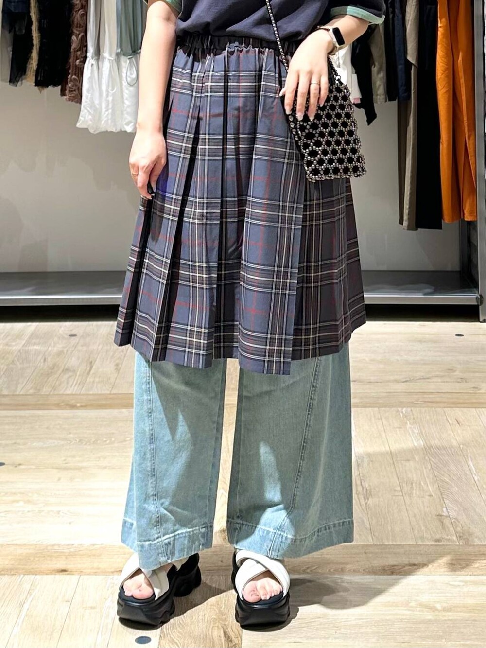 ブルー系のデニムパンツ、シルバー系のショルダーバッグ、ホワイト系のサンダルを着用したレディースの夏コーディネートの6枚目の写真