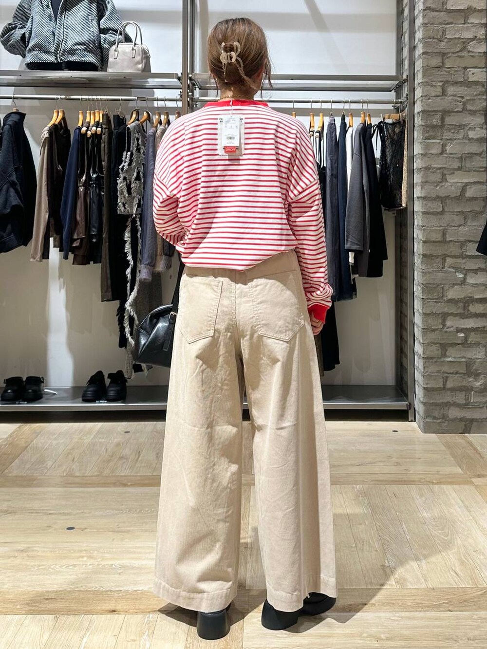 レッド系のTシャツ/カットソー、ブラック系のサンダル、ホワイト系のその他パンツを着用したレディースの秋コーディネートの4枚目の写真