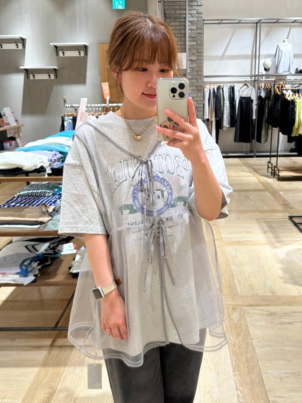 ホワイト系のサンダル、グレー系のベスト、ブラック系のデニムパンツを着用したレディースの春コーディネートの6枚目の写真