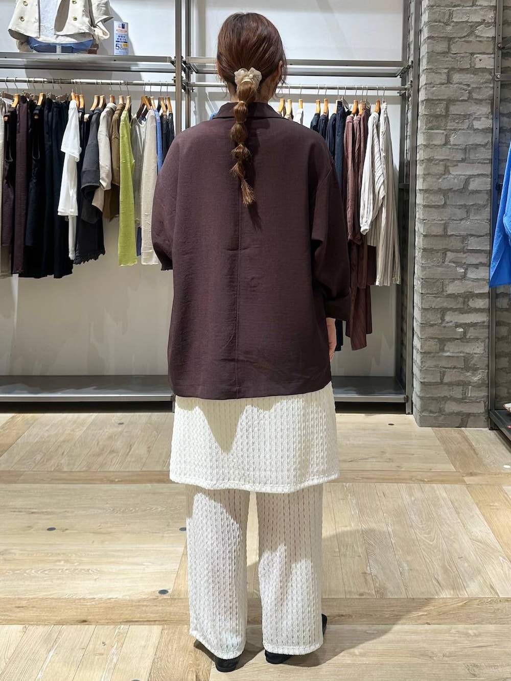 ブラック系のショルダーバッグ、ブラック系のパンプス、ブラウン系のテーラードジャケットを着用したレディースの春コーディネートの3枚目の写真