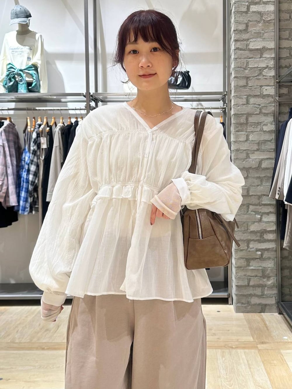 ブラウン系のボストンバッグ、ホワイト系のTシャツ/カットソー、ベージュ系のスウェットパンツを着用したレディースの春コーディネートの4枚目の写真