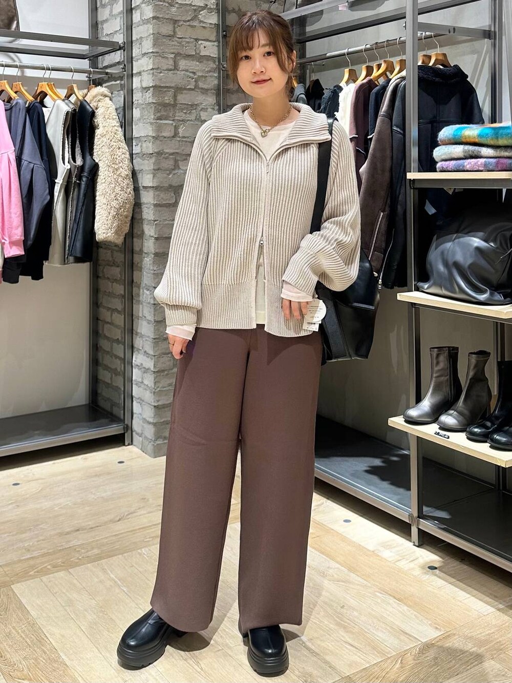 ホワイト系のカーディガン/ボレロ、ブラウン系のその他パンツ、ブラック系のショルダーバッグを着用したレディースの秋コーディネートの5枚目の写真