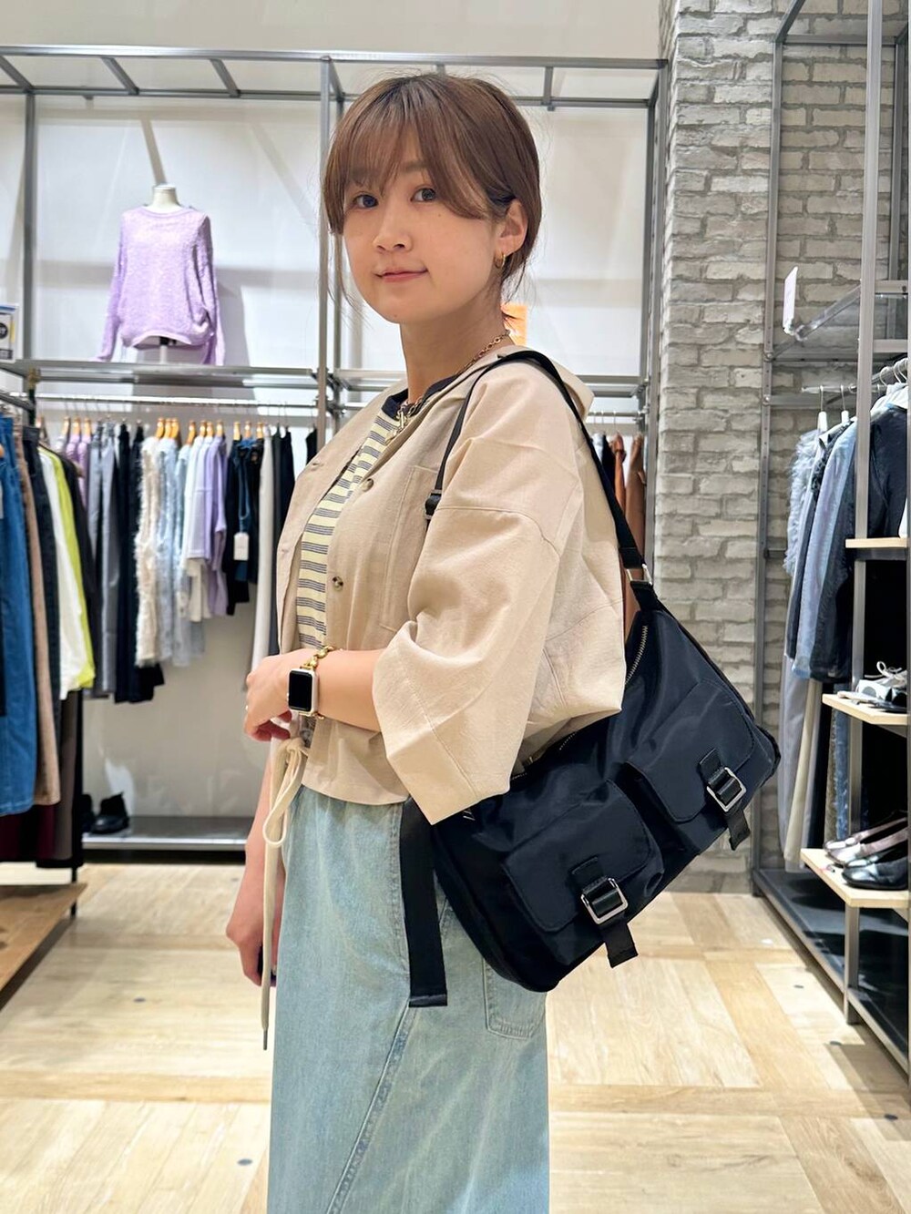 イエロー系のタンクトップ、ベージュ系のシャツ/ブラウス、ブラック系のショルダーバッグを着用したレディースの春コーディネートの4枚目の写真